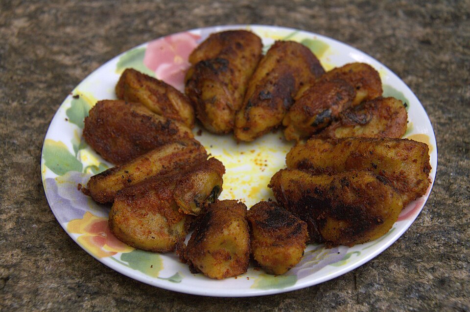 Kallummakkaya Nirachath: A golden-fried image of Kallummakkaya Nirachath, a traditional Malabar delicacy of mussels stuffed with a spiced rice paste and fried in their shells.