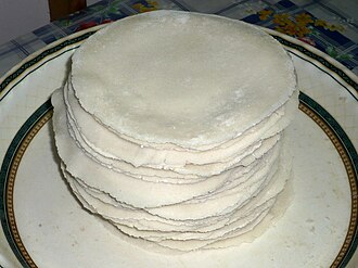 A pristine white Malabar Pathiri, a traditional thin and soft rice pancake from Kerala, expertly crafted from roasted rice flour dough and cooked on a dry griddle.