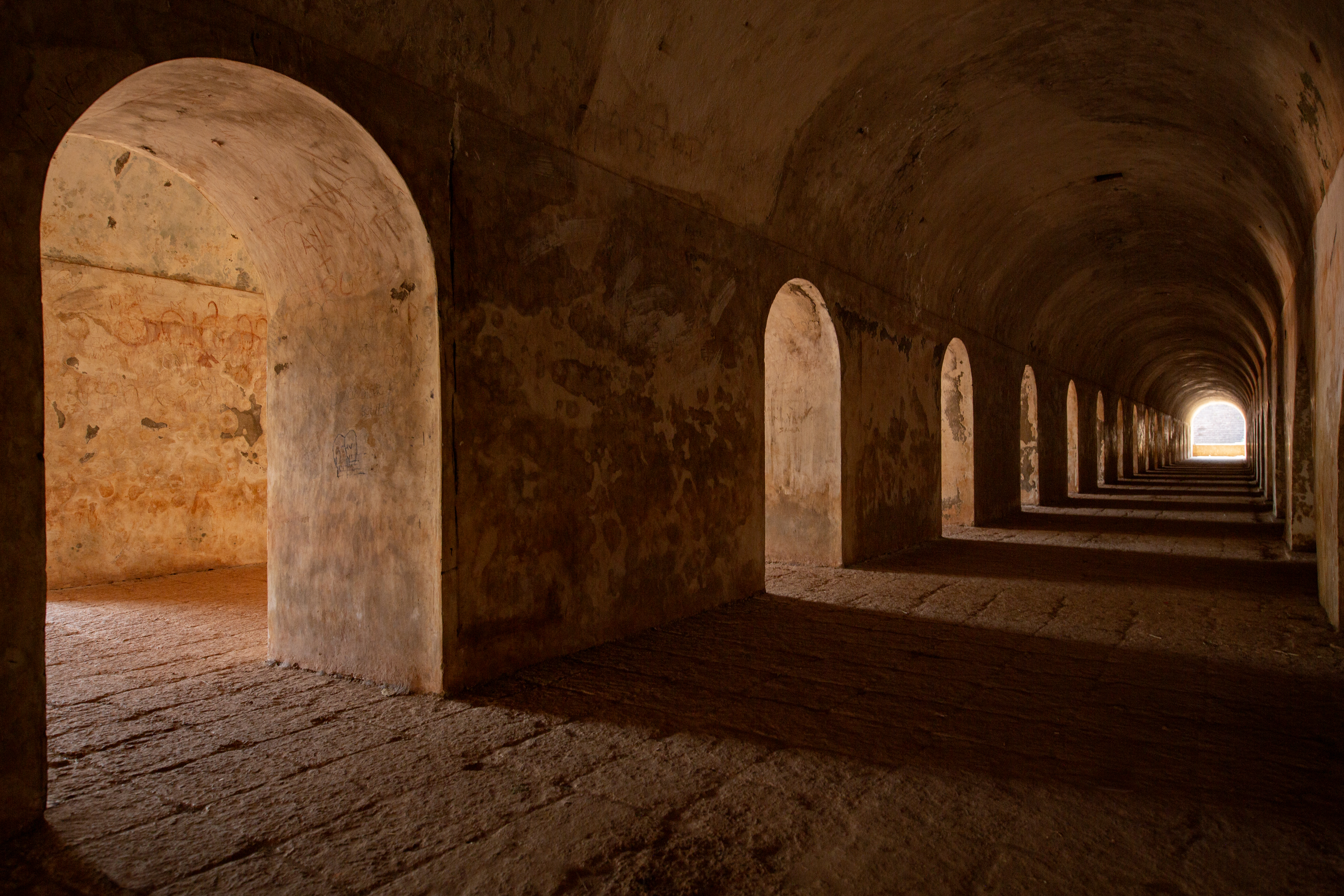The massive, dark brown laterite stone walls and ramparts of the historic colonial St. Angelo Fort in Kannur